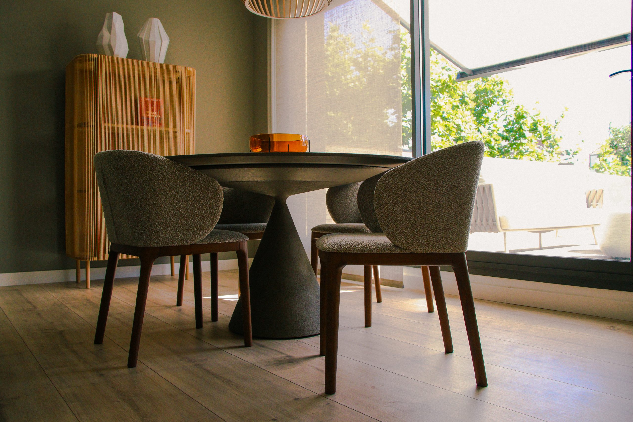 Fotografía profesional de un comedor muy bien iluminado y en tonos verdes y marrones.